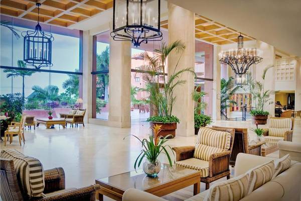 Foyer des Tivoli La Caleta Tenerife Resorts mit Sofas, Tischen, Pflanzen und Kronleuchtern