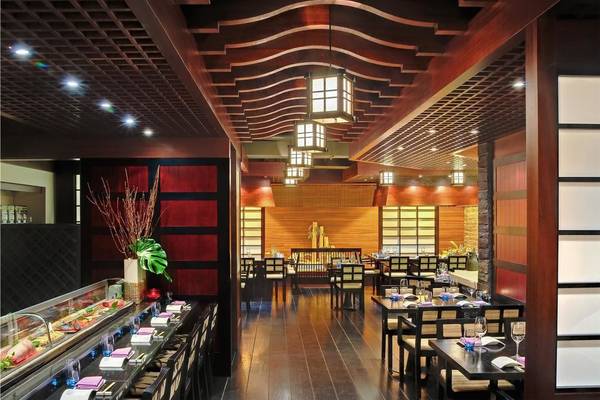 Innenansicht des Sushi-Restaurants im Tivoli La Caleta Tenerife Resort mit Holztischen, Stühlen und traditioneller Beleuchtung.