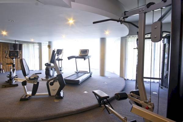 Fitnessstudio im Beyond Resort Krabi mit verschiedenen Geräten wie Laufband, Ergometer und Hantelbank.