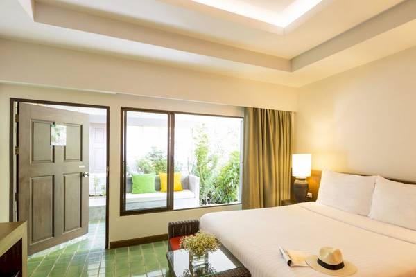 Innenansicht eines Zimmers im Beyond Resort Krabi mit offenem Eingang, großem Fenster und grünem Boden.