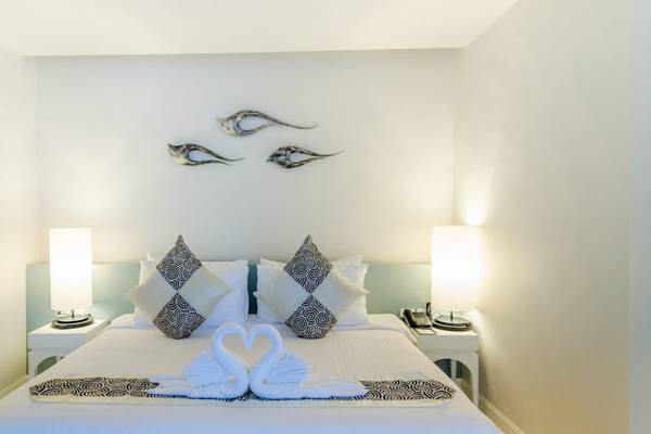 Ein elegantes Hotelzimmer im Beyond Resort Krabi mit zwei weißen Schwänen auf dem Bett.
