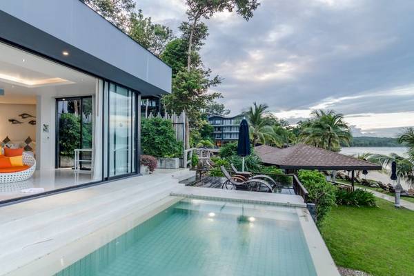 Pool-Ansicht der Villa im Beyond Resort Krabi mit Lounge-Möbeln und Meer im Hintergrund.