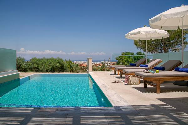 Terrasse mit Swimmingpool und Sonnenliegen im Louis St. Elias Resort & Waterpark
