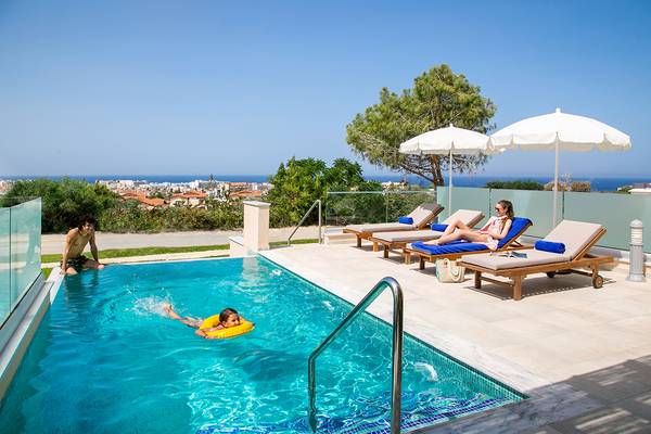 Ein Pool mit Sonnenliegen und Sonnenschirmen am Louis St. Elias Resort & Waterpark.