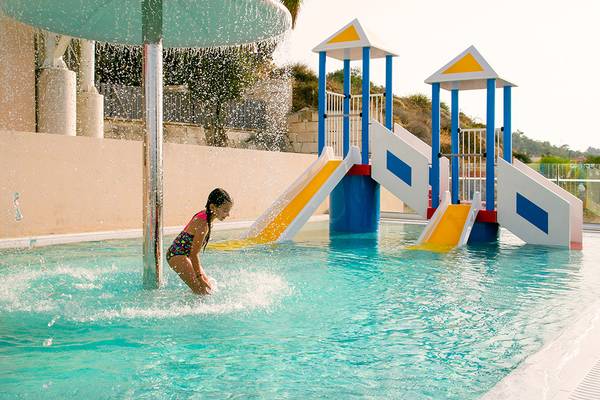 Ein junges Mädchen spielt im Wasserpark des Louis St. Elias Resorts.