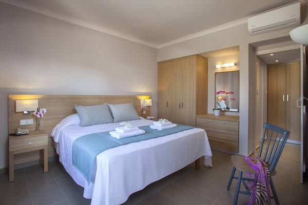 Zimmer im Louis St. Elias Resort & Waterpark mit Bett, Nachttischen und Kleiderschrank