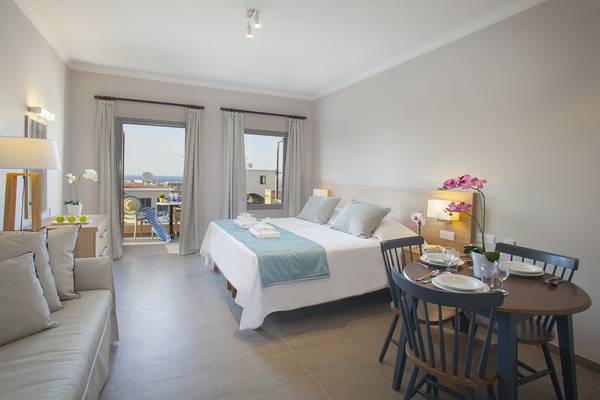 Hotelzimmer im Louis St. Elias Resort & Waterpark mit Bett, Tisch und Balkon.