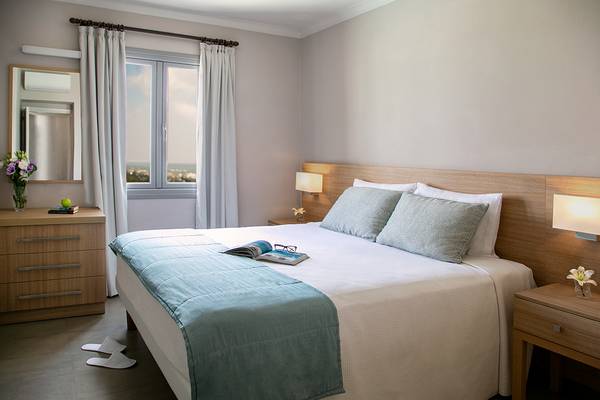 Louis St. Elias Resort, modernes Schlafzimmer mit Doppelbett und Lesematerial