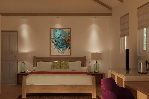 Innenansicht eines Schlafzimmers im Ellaidhoo Maldives by Cinnamon Hotel mit einem großen Bett, Gemälde an der Wand, Nachttischen und Lampen.