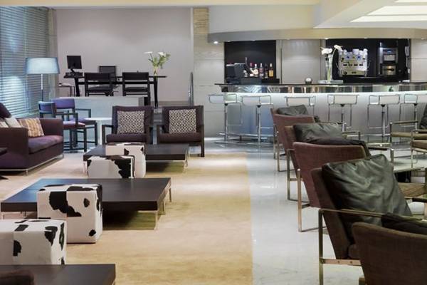 Hotellobby des H10 Gran Tinerfe mit Bar, Sofas und Stühlen.