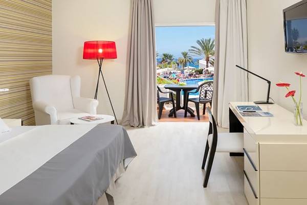 Ein modernes Hotelzimmer im H10 Gran Tinerfe mit Blick auf den Pool und die Terrasse.