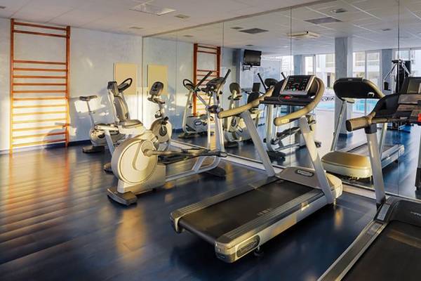 Fitnessraum im H10 Gran Tinerfe Hotel mit Laufbändern, Fahrradtrainern und anderen Geräten.