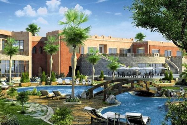 Luftaufnahme des Stella Gardens Resort & Spa Makadi Bay mit Swimmingpool, Liegestühlen und Palmen.