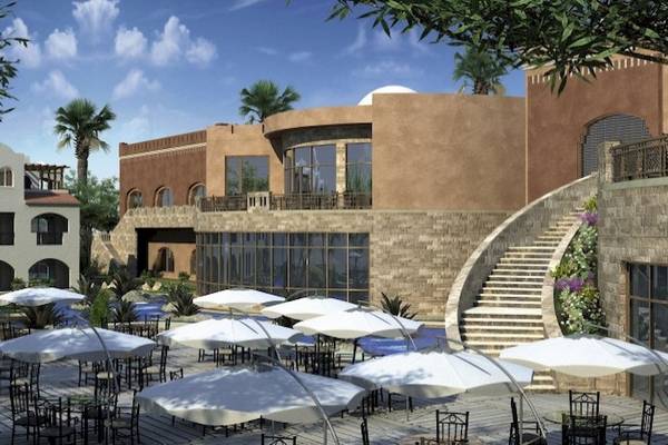 Außenbereich des Stella Gardens Resort & Spa Makadi Bay mit vielen weißen Sonnenschirmen und Tischen.