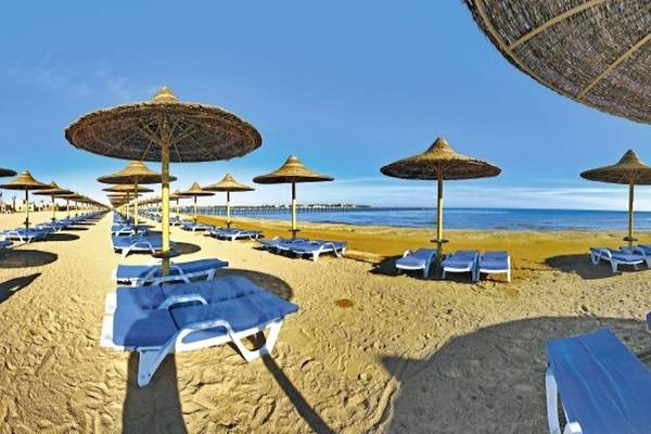 Strand des Stella Gardens Resort & Spa Makadi Bay mit Liegen und Sonnenschirmen.
