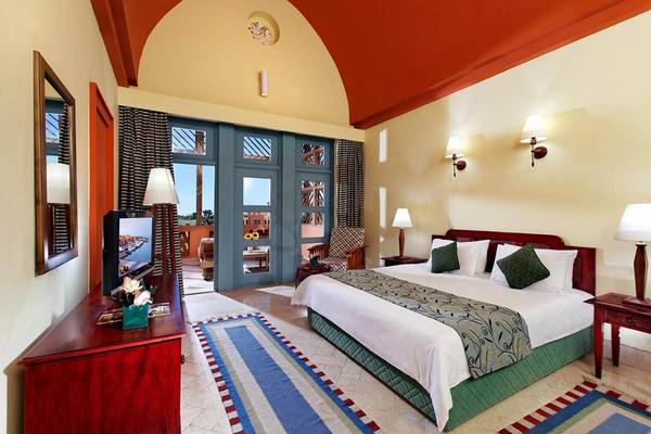 Zimmer im Steigenberger Golf Resort El Gouna mit Kingsize-Bett, Fernseher, Möbeln und offenem Balkon.