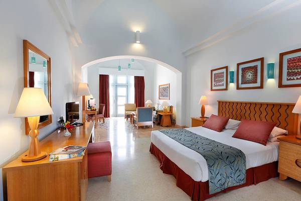 Hotelzimmer im Steigenberger Golf Resort El Gouna mit einem großen Bett und Einrichtung.