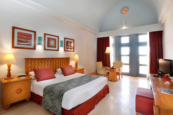 Ein elegantes Hotelzimmer im Steigenberger Golf Resort El Gouna mit zwei Betten, Lampen und einem Fernseher.