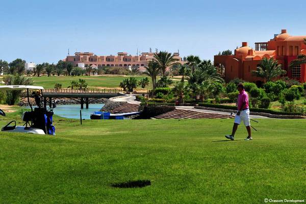 Golfplatz im Steigenberger Golf Resort El Gouna mit Gebäuden im Hintergrund.
