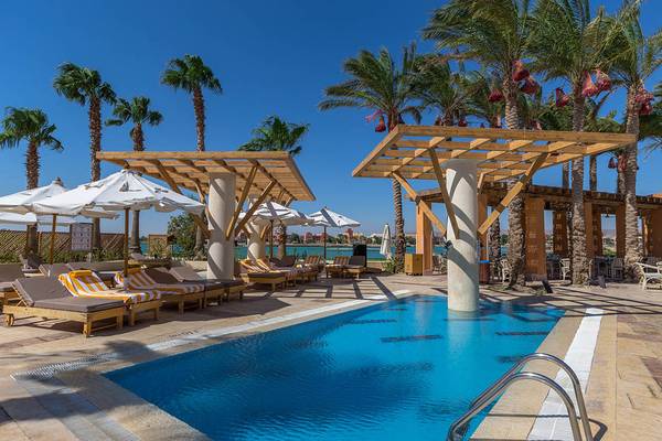 Pool-Lounge-Bereich im Steigenberger Golf Resort El Gouna mit Sonnenliegen, Sonnenschirmen und einer blauen Poolfläche.