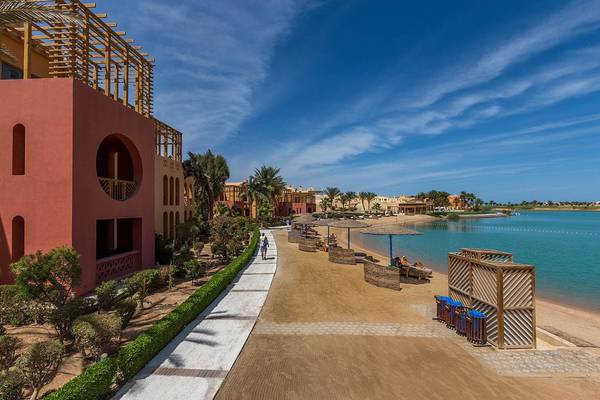 Außenansicht des Steigenberger Golf Resort El Gouna mit Strand, Gebäuden und Bäumen.