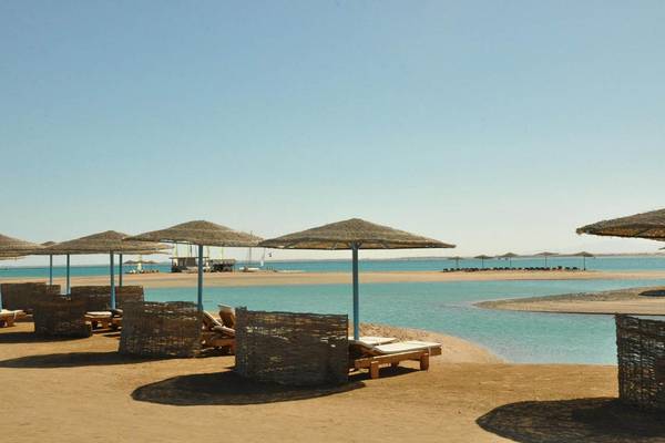 Strand mit Liegen und Sonnenhuten im Steigenberger Golf Resort El Gouna
