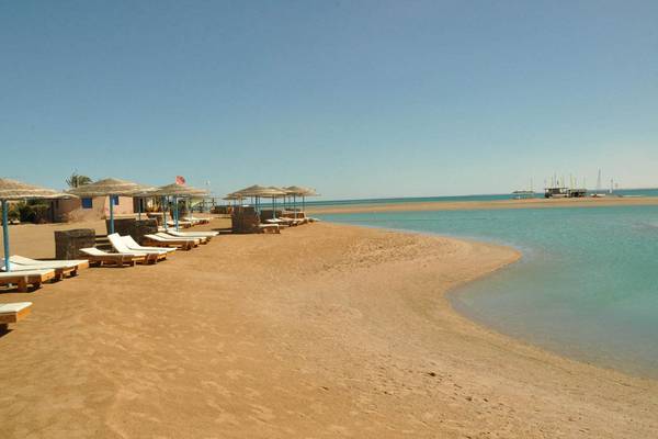 Strand mit Liegen und Sonnenhuten im Steigenberger Golf Resort El Gouna