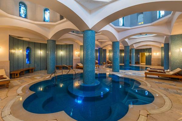 Innenansicht des Spa-Bereichs im Steigenberger Golf Resort El Gouna mit zwei blauen Schwimmbecken und Säulen.