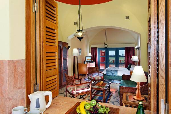 Innenansicht eines Hotelzimmers mit Wohnbereich, Schlafzimmer und Balkon