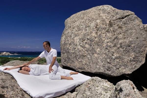 Massage im Freien unter großen Felsen im Resort Valle Dell'Erica Thalasso & Spa