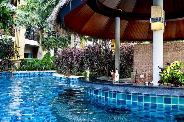 Pool-Bar im Rawai Palm Beach Resort mit blauen Fliesen und tropischen Pflanzen im Hintergrund.