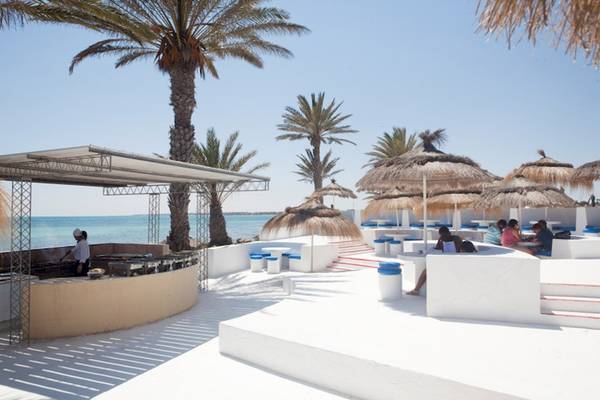 Terrasse im El Mouradi Djerba Menzel Hotel mit Palmen und Blick auf das Meer.