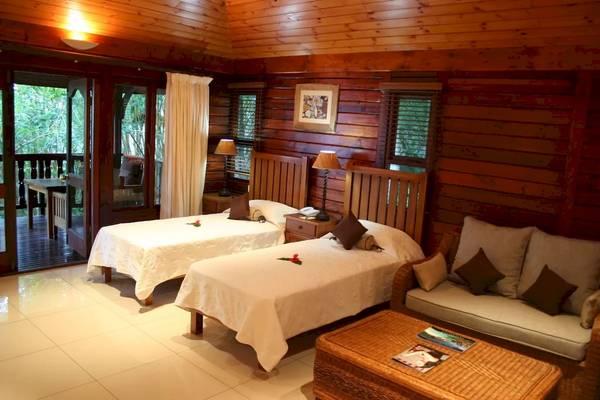 Ein Schlafzimmer mit zwei Betten, einer Couch und einem Tisch im Cerf Island Resort.