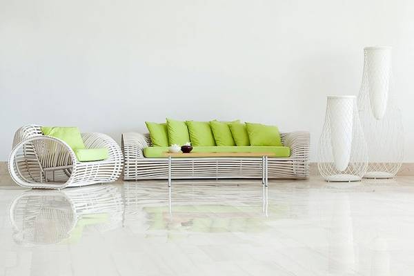 Wohnzimmer im Lindos Bay Hotel mit weißen Möbeln, grünen Kissen und runden weißen Vasen.