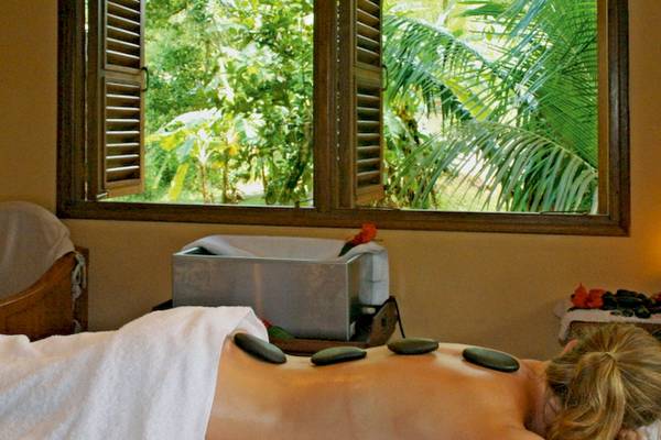 Eine Frau erhält eine Massage im Hotel Cerf Island Resort mit Blick auf den Garten.
