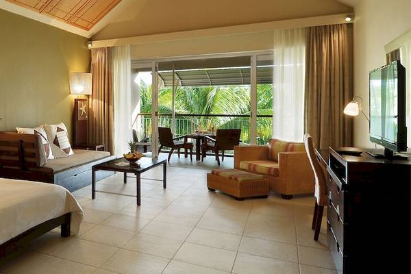 Suite im Victoria Beachcomber Resort & Spa mit Bett, Sofa, Tisch und Terrassenzugang