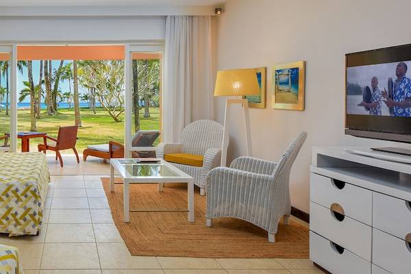 Hotelzimmer im Victoria Beachcomber Resort & Spa mit Meerblick, zwei Betten, Wohnzimmermöbeln und einer Terrasse.