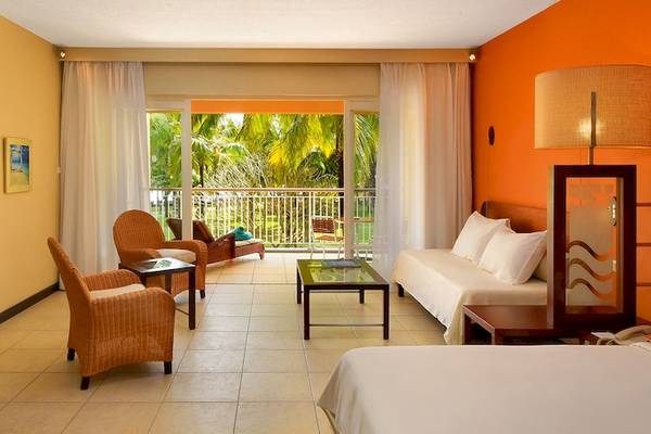 Hotelzimmer im Victoria Beachcomber Resort & Spa mit Fernseher, Möbeln und Balkon.