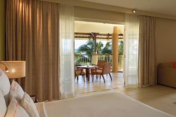 Innenansicht der Suite im Victoria Beachcomber Resort & Spa mit Blick auf Terrasse und Meer.