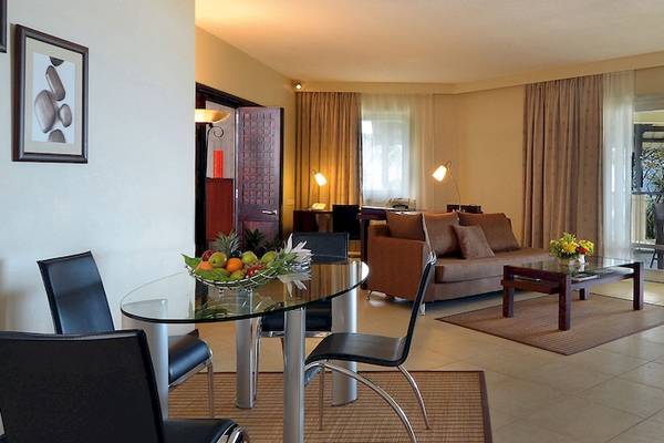 Wohnbereich des Victoria Beachcomber Resorts mit einem Sofa, einem Tisch und einer Terrasse mit Blick auf die Landschaft.