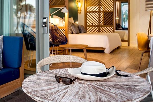 Innenansicht eines Zimmers im Victoria Beachcomber Resort mit einem Bett, Möbeln und Accessoires.
