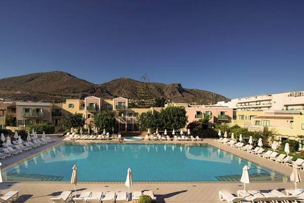 Außenpool des Silva Beach Hotels mit Sonnenliegen und Berg im Hintergrund