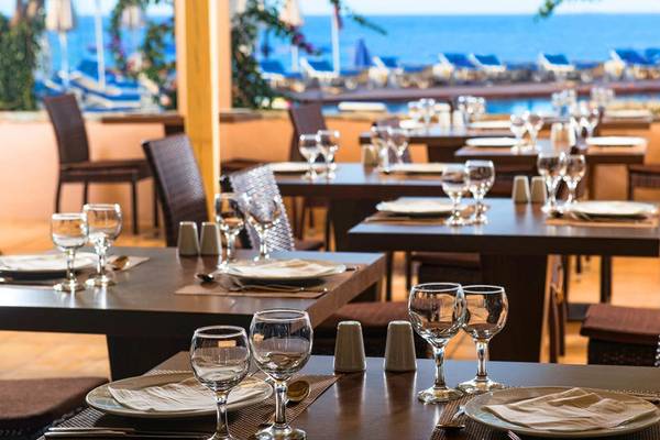 Innenansicht des Restaurants im Silva Beach Hotel mit Blick auf das Meer und Sonnenliegen.