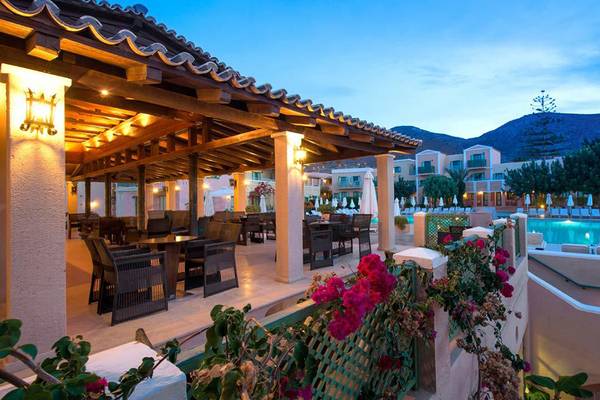 Außenbereich des Silva Beach Hotels mit Swimmingpool, Tischen und Stühlen und Blick auf die Berge