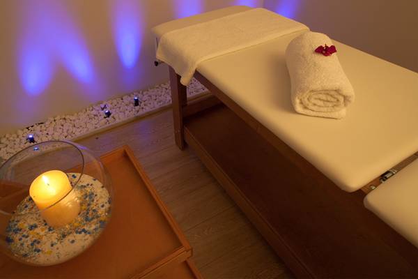 Relaxationsbereich im Silva Beach Hotel mit Massageliege, Kerze und Steinen