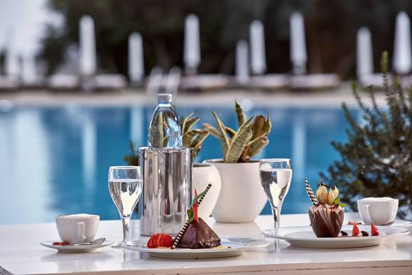 Griechischer Park Hotel Pooltisch mit Speisen und Getränken.