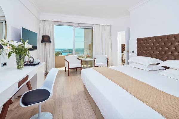 Schlafzimmer im Grecian Park Hotel mit Meerblick, modernem Design und Komforteinrichtungen.