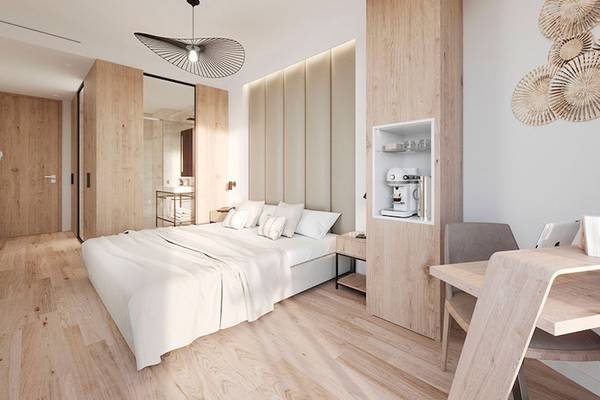 Ein modernes Hotelzimmer mit einem Bett, Schreibtisch und Kaffeemaschine.