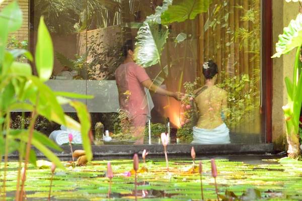 Massage im Garten des Bamboo Village Beach Resort & Spa mit zwei Personen und Pflanzen im Hintergrund.
