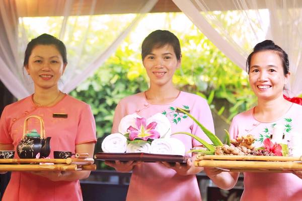 Drei Frauen im rosa Kleid präsentieren Geschenke im Bamboo Village Beach Resort & Spa.